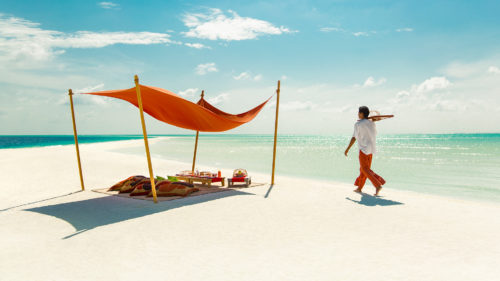 Man serving drinks to a personalised camp in the Maldives